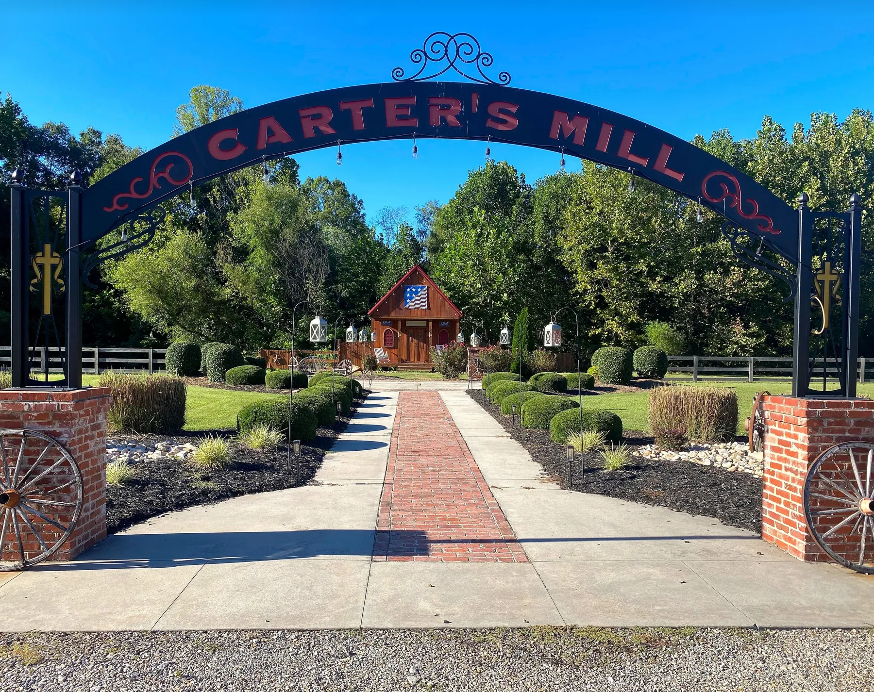 The Carter's Mill arch over the brick path, with the little chapel behind it